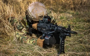 KMG556CL ile prone pozisyonda mevzilenmiş asker, çim arazi
