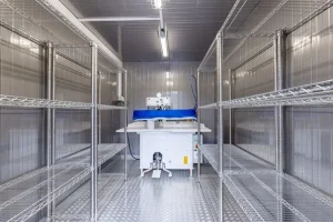 Konteyner içinde metal raf sistemleri ve bir ütü/pres makinesi