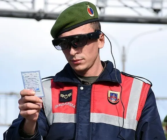Jandarma üniformalı bir personel artırılmış gerçeklik gözlüğü takarak elindeki kimlik kartını okutuyor
